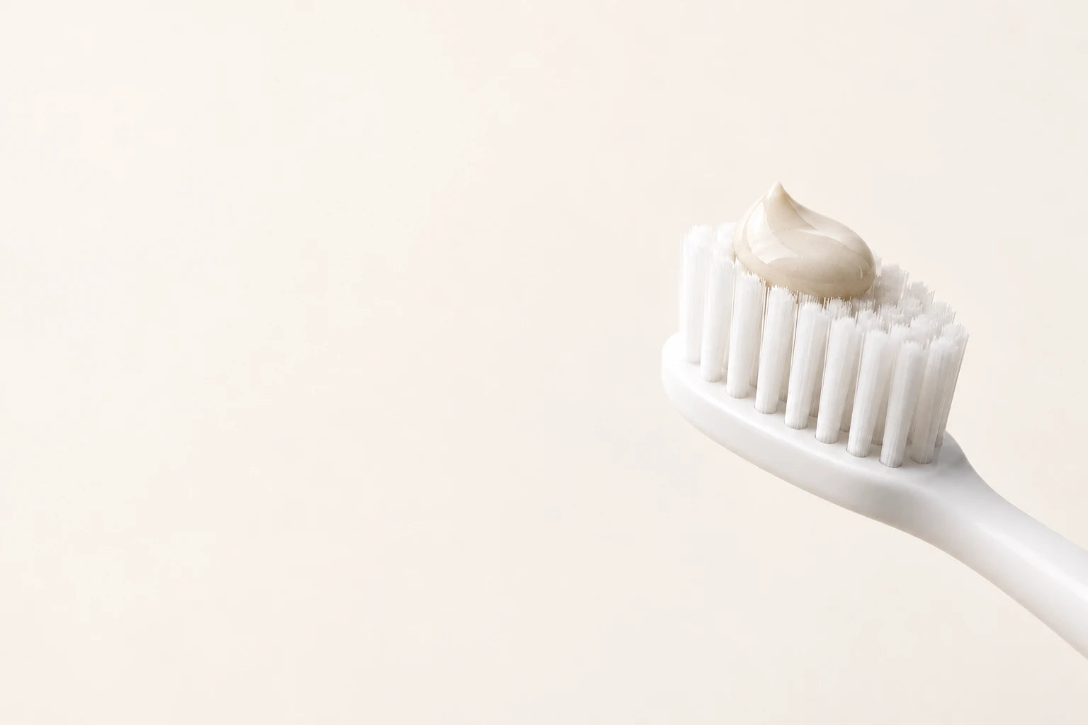 A small dab of toothpaste on a white toothbrush