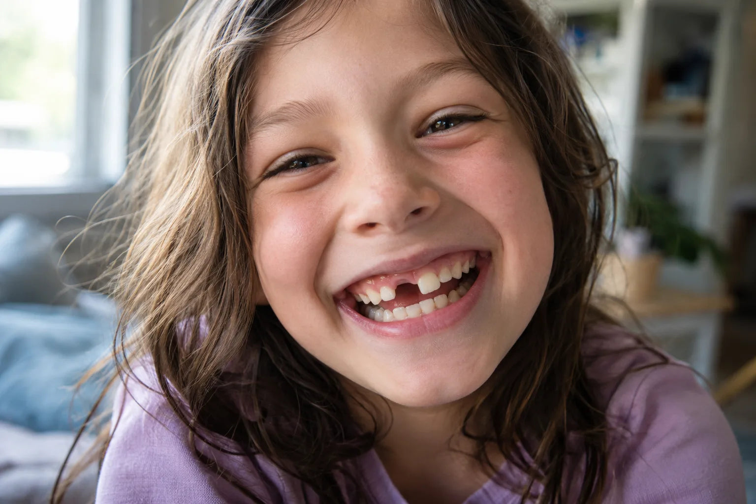 A laughing child with a missing front tooth